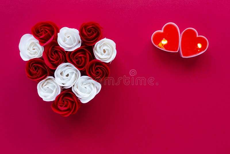 Valentines day red background with heart from rose flowers and two heart shape candles. royalty free stock photo Valentines day red background with heart from rose flowers and two heart shape candles. royalty free stock photo