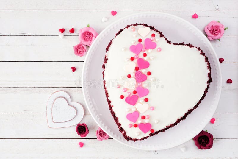 Valentines Day red velvet heart shaped cake over a white wood background