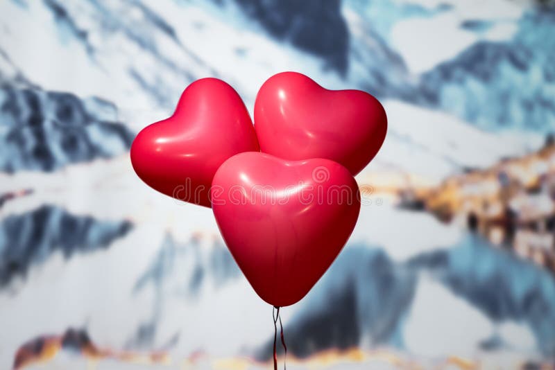 Valentines day.  three reds balloons in form of heart on the snowy mountain background. Beach. Concept.