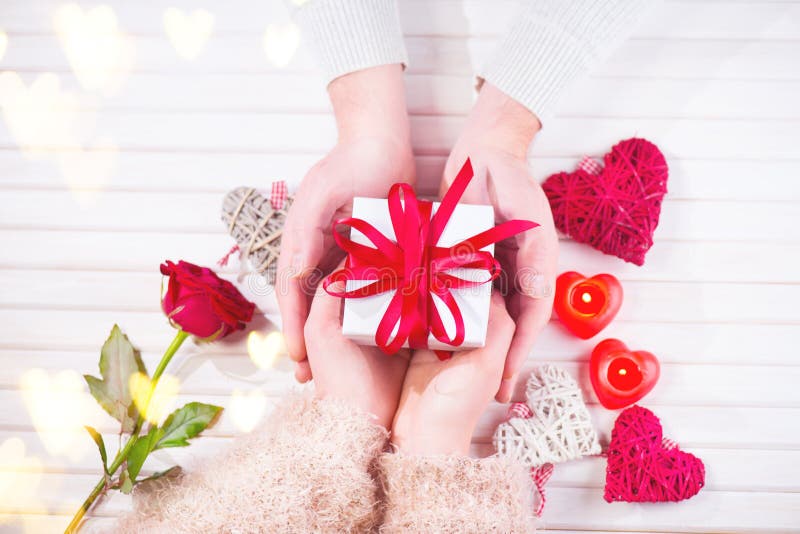 Valentinsgruß `s Tag Junges Paar übergibt das Halten der Geschenkbox über weißem hölzernem Hintergrund Zu küssen Mann und Frau un lizenzfreies stockbild Valentinsgruß `s Tag Junges Paar übergibt das Halten der Geschenkbox über weißem hölzernem Hintergrund Zu küssen Mann und Frau un lizenzfreies stockbild