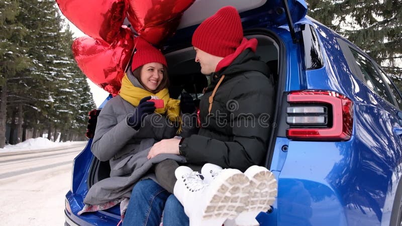 Valentinsk gåva. ett lyckligt ungt par med valentindag eller födelsedagspresent. lycklig man ger en gåva till sin flickvän