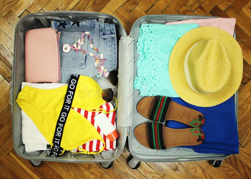 Valise rassemblée pour le voyage Valise en plan rapproché ouvert de vue avec des choses au repos sur un fond en bois images stock Valise rassemblée pour le voyage Valise en plan rapproché ouvert de vue avec des choses au repos sur un fond en bois images stock