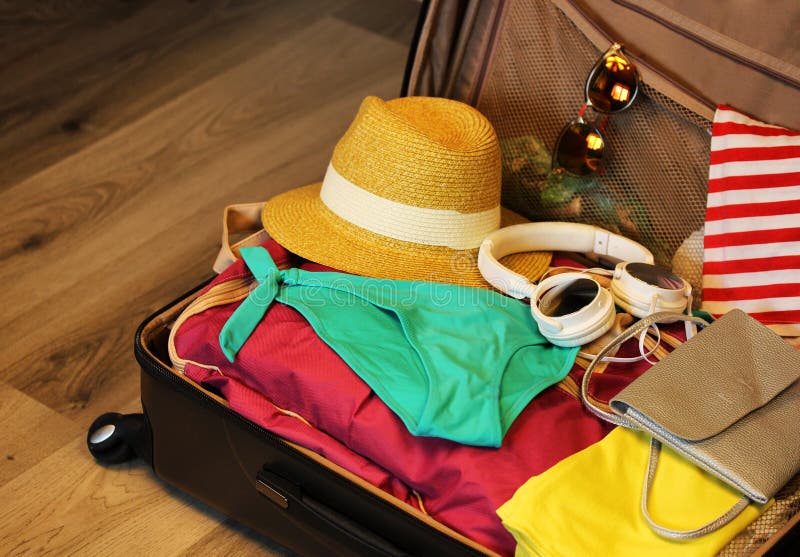 Valise rassemblée pour le voyage Valise en plan rapproché ouvert de vue avec des choses au repos sur un fond en bois images stock Valise rassemblée pour le voyage Valise en plan rapproché ouvert de vue avec des choses au repos sur un fond en bois images stock