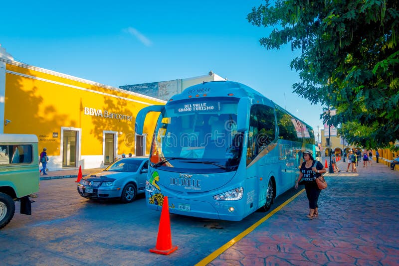 VALLADOLID, MEXIKO - 12. NOVEMBER 2017: Nicht identifizierte Frau, die nah an einem touristict Bus parket in der Straße von a geh lizenzfreies stockfoto VALLADOLID, MEXIKO - 12. NOVEMBER 2017: Nicht identifizierte Frau, die nah an einem touristict Bus parket in der Straße von a geh lizenzfreies stockfoto