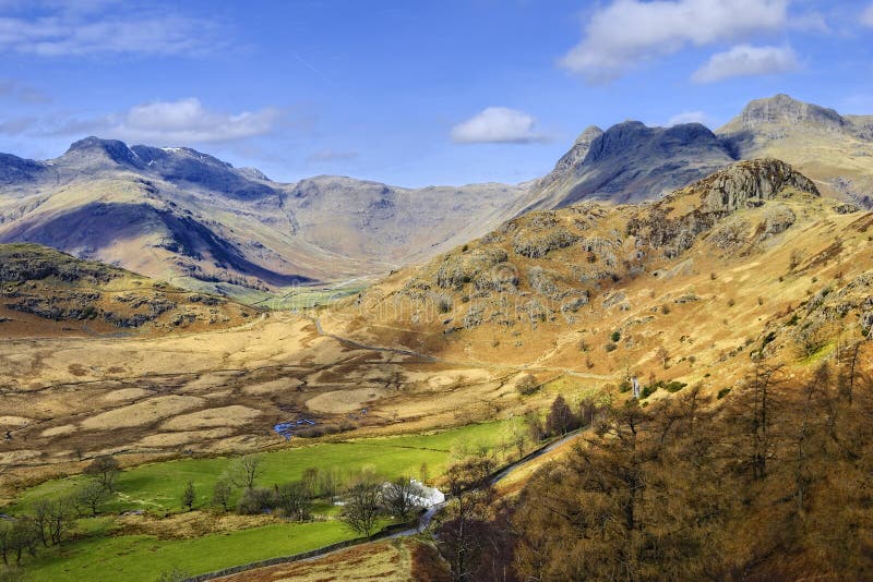 Aerial view of the head of the Langdale valley, a popular tourist area of the English Lake District National Park. The mountains in the distance are the Langdale Pikes to the right, and Bowfell on the left. Aerial view of the head of the Langdale valley, a popular tourist area of the English Lake District National Park. The mountains in the distance are the Langdale Pikes to the right, and Bowfell on the left.