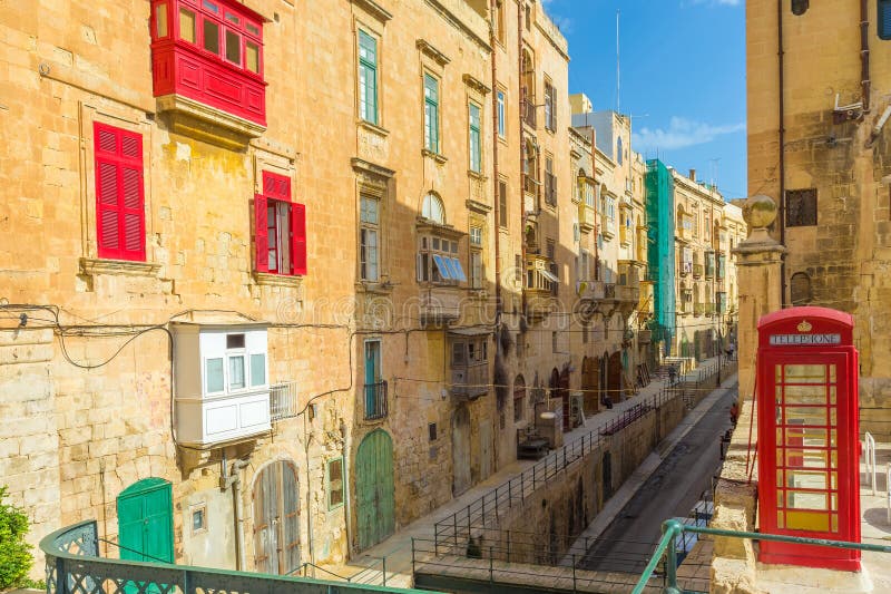 Valletta streetview med röda balkonger och telefonbåset - Malta royaltyfria foton Valletta streetview med röda balkonger och telefonbåset - Malta royaltyfria foton