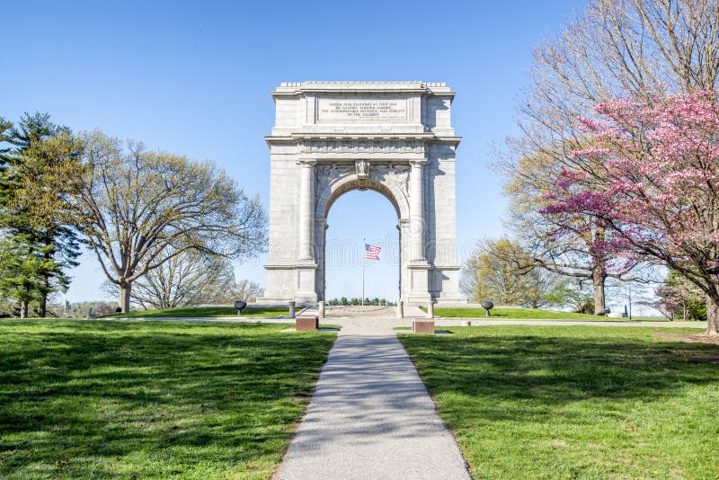 Valley Forge National Park, Pennsylvania. Monument and American flag at Valley Forge National Park, Pennsylvania against blue skies on sunny day royalty free stock photos Valley Forge National Park, Pennsylvania. Monument and American flag at Valley Forge National Park, Pennsylvania against blue skies on sunny day royalty free stock photos