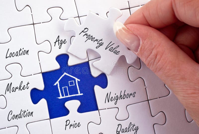 Valor de una propiedad - mano femenina con rompecabezas de las propiedades inmobiliarias Valor de una propiedad - mano femenina con rompecabezas de las propiedades inmobiliarias