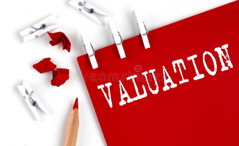 VALUATION text on red paper with office tools on the white background stock photos