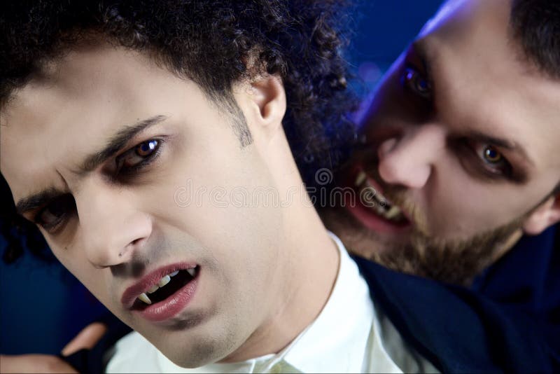 Vampire masculin attaquant l'autre vampire désespéré regardant l'appareil-photo photos stock Vampire masculin attaquant l'autre vampire désespéré regardant l'appareil-photo photos stock