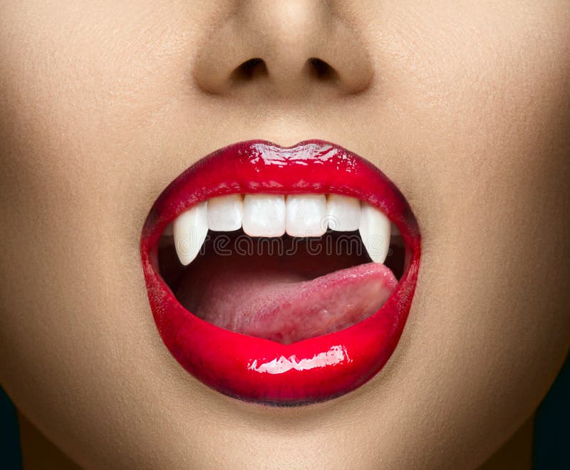 Vampiro Sexy, os lábios vermelhos da mulher são próximos Garota vampira lambendo presas com língua Fashion Glamor Halloween foto de stock royalty free Vampiro Sexy, os lábios vermelhos da mulher são próximos Garota vampira lambendo presas com língua Fashion Glamor Halloween foto de stock royalty free