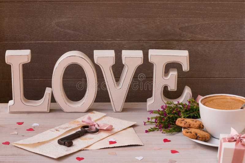 Van de de dagdecoratie van Valentine ` s dichte omhooggaand De kop van koffie, de giften, de bloemen en het woord houden van op h stock afbeelding Van de de dagdecoratie van Valentine ` s dichte omhooggaand De kop van koffie, de giften, de bloemen en het woord houden van op h stock afbeelding