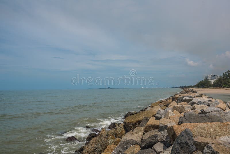 Van de overzeese de rots van het de lijneffect golvenzweep op het strand onder blauwe hemel stock afbeelding Van de overzeese de rots van het de lijneffect golvenzweep op het strand onder blauwe hemel stock afbeelding