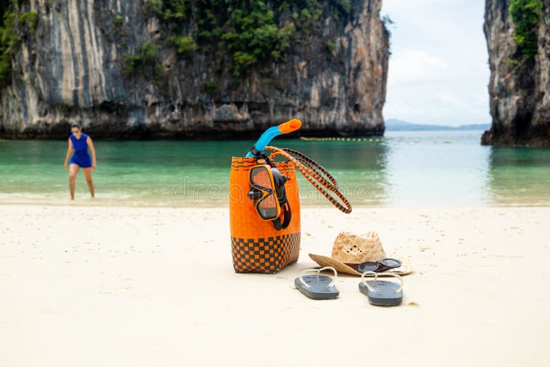 Van de strandzak en reis toebehoren met vrouw op onduidelijk beeldachtergrond op vakantie stock foto Van de strandzak en reis toebehoren met vrouw op onduidelijk beeldachtergrond op vakantie stock foto