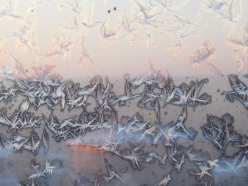 Van het de vorstijs van de vogelvorm de kristallenvormingen op een glazen venster Frostworkpatroon op achtergrond van de ochtend royalty-vrije stock foto Van het de vorstijs van de vogelvorm de kristallenvormingen op een glazen venster Frostworkpatroon op achtergrond van de ochtend royalty-vrije stock foto