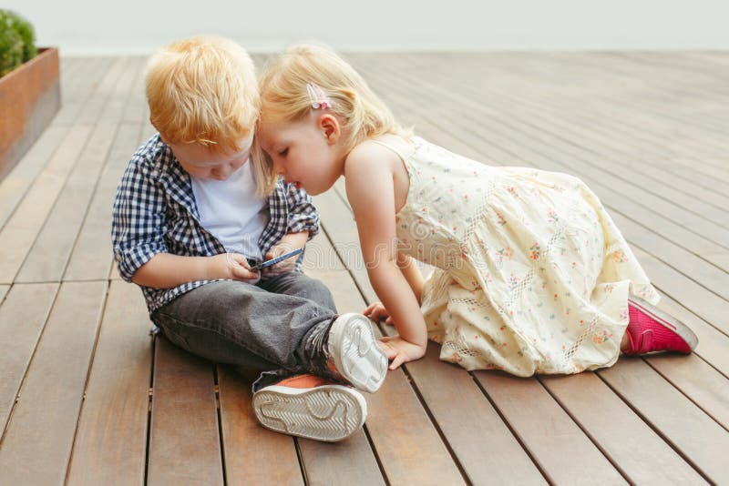 Van het twee leuke aanbiddelijke witte Kaukasische peutersjongen en meisje zitting samen en speelspelen op digitale tablet van de stock fotografie Van het twee leuke aanbiddelijke witte Kaukasische peutersjongen en meisje zitting samen en speelspelen op digitale tablet van de stock fotografie