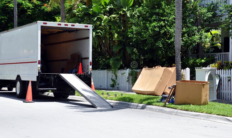 Mover's Van Parked On Street With Boxes, Furniture And Moving Equipment. Mover's Van Parked On Street With Boxes, Furniture And Moving Equipment