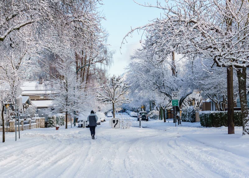 VANCOUVER, CANADA - February 24, 2018: Winter morning after a night of snow blizzard man running on Heather street.