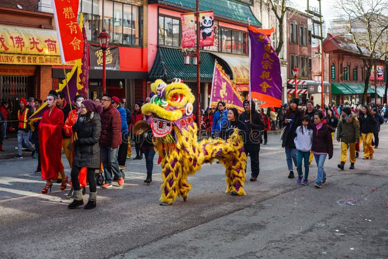 VANCOUVER, KANADA - 18. Februar 2014: Leute in gelbem Lion Costume am Chinesischen Neujahrsfest führen in Vancouver Chinatown vor stockfoto VANCOUVER, KANADA - 18. Februar 2014: Leute in gelbem Lion Costume am Chinesischen Neujahrsfest führen in Vancouver Chinatown vor stockfoto