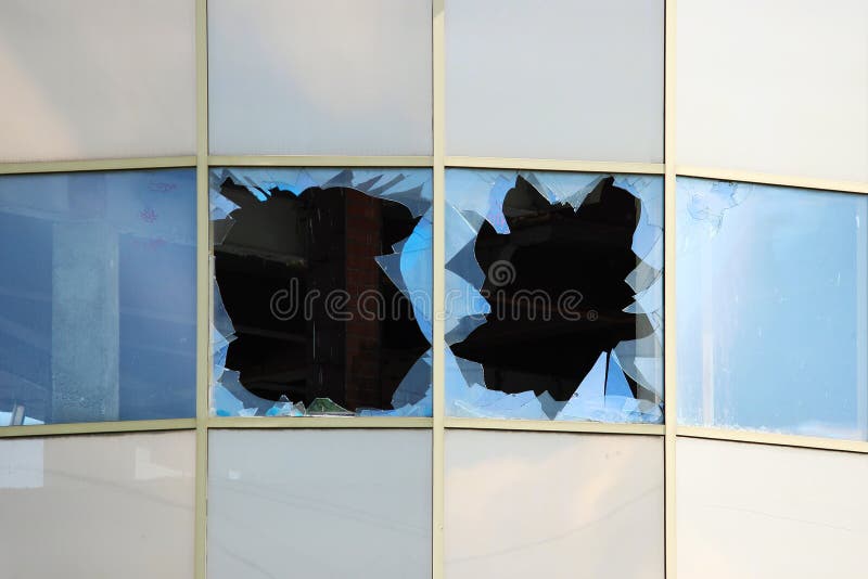 vandal broken windows in an abandoned shopping center building that stands unguarded.