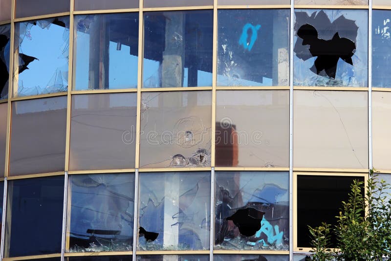 vandal broken windows in an abandoned shopping center building that stands unguarded.