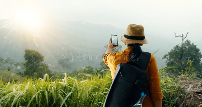Vandra genom att använda smartphonen som tar bilden härligt landskap på bergmaximum, medan undersökning som trekking i tropisk re arkivbilder