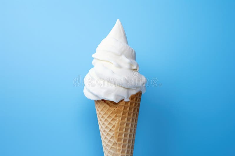 A vanilla ice cream cone against a powder blue backdrop royalty free stock images