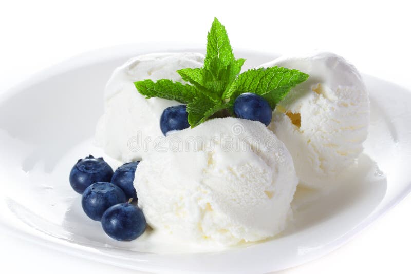 Vanilla ice cream with mint and blueberries on a platter on white background