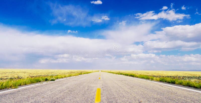 Vanishing point. A straight road in Wyoming disappearing in the distance. A straight Wyoming road disappearing in the distance. Under a bright blue sky and stock image Vanishing point. A straight road in Wyoming disappearing in the distance. A straight Wyoming road disappearing in the distance. Under a bright blue sky and stock image