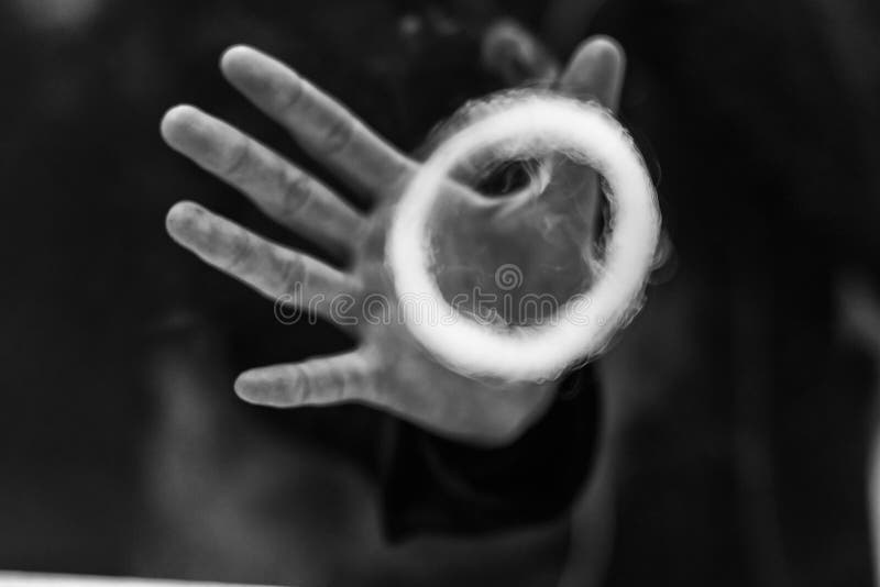 Vape man. Young handsome white guy let rings out of steam. Vaping. Electronic cigarette. Black and white photo.