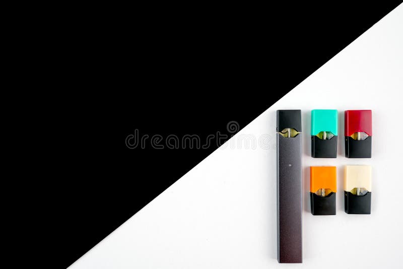 Vaping device and colored vaping pods on black and white diagonal background. Technology and nicotine concept..High end product photography theme with copy space for text