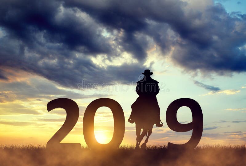 Vaqueiro que monta um cavalo no por do sol Envie ao ano novo 2019 fotografia de stock Vaqueiro que monta um cavalo no por do sol Envie ao ano novo 2019 fotografia de stock