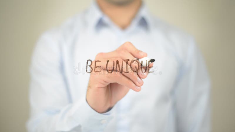 Be Unique, Man writing on transparent screen,high quality. Be Unique, Man writing on transparent screen,high quality