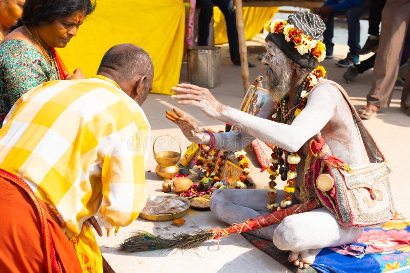 VARANASI, INDE, LE 10 MARS 2019 - l'homme saint indou non identifi? de Sadhu, s'assied sur le ghat pr?s du Gange ? Varanasi photographie stock VARANASI, INDE, LE 10 MARS 2019 - l'homme saint indou non identifi? de Sadhu, s'assied sur le ghat pr?s du Gange ? Varanasi photographie stock