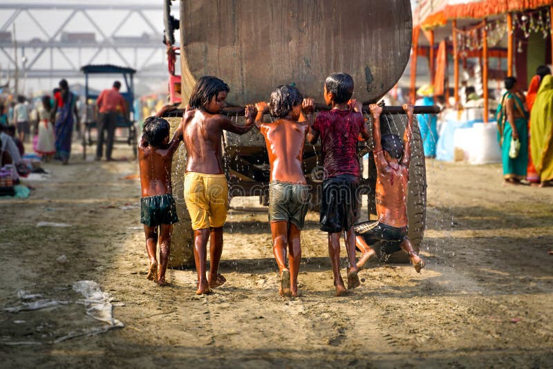 Varanasi/India-09 11 2018: indiska ungar som spelar med vattenbehållaren royaltyfri foto Varanasi/India-09 11 2018: indiska ungar som spelar med vattenbehållaren royaltyfri foto