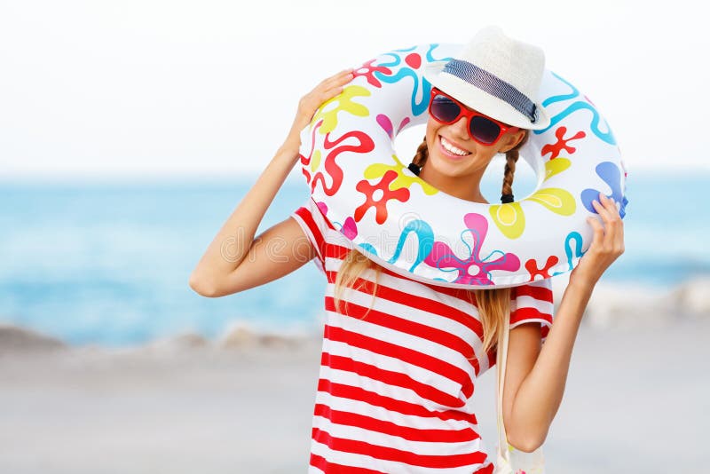 Vare la mujer feliz y las gafas de sol coloridas y el sombrero de la playa que llevan que se divierte el verano durante vacacione imagen de archivo