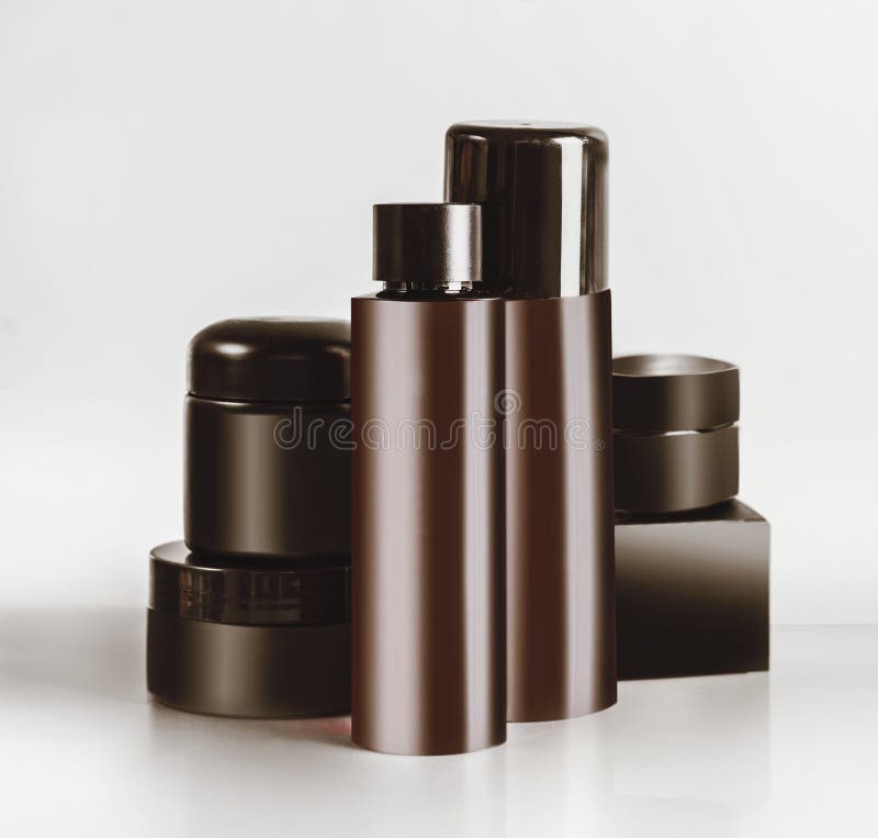 Vari barattoli e bottiglie cosmetici neri e marroni del prodotto con derisione marcante a caldo su, stando sulla tavola leggera a fotografia stock libera da diritti Vari barattoli e bottiglie cosmetici neri e marroni del prodotto con derisione marcante a caldo su, stando sulla tavola leggera a fotografia stock libera da diritti