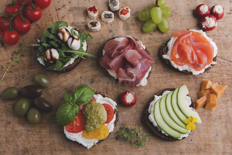 Variation av canape med laxen, prosciutto, avokado, mozzarella, tomat, pesto, oliv, gräddost Blandning av olik mellanmål och appe royaltyfri foto Variation av canape med laxen, prosciutto, avokado, mozzarella, tomat, pesto, oliv, gräddost Blandning av olik mellanmål och appe royaltyfri foto