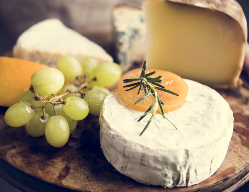 Variation de fromage et des raisins verts sur un aliment en bois pH de plateau photo stock Variation de fromage et des raisins verts sur un aliment en bois pH de plateau photo stock