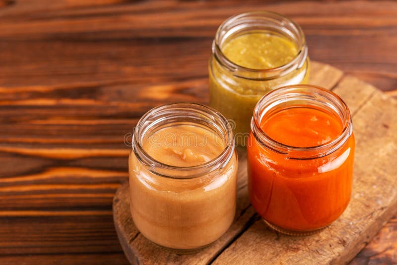 Variation pureed baby food in glass jars on cutting board stock photos Variation pureed baby food in glass jars on cutting board stock photos