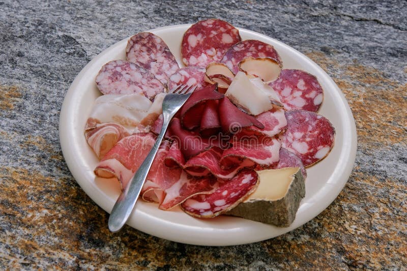 Variedad típica auténtica de productos de carne fría elaborados y queso de cabra de montaña en una marca de charco blanco ticino s