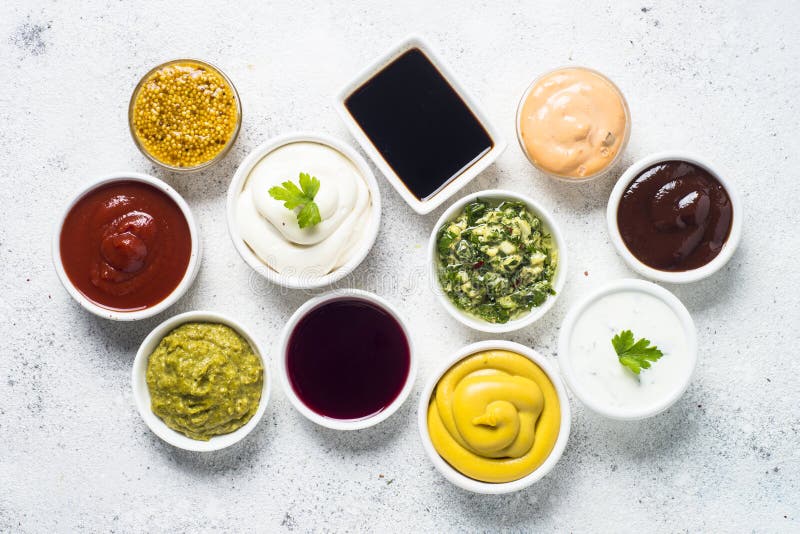 Set of sauces - ketchup, mayonnaise, mustard soy sauce, bbq sauce, pesto, chimichurri, mustard grains and pomegranate sauce on white background. Set of sauces - ketchup, mayonnaise, mustard soy sauce, bbq sauce, pesto, chimichurri, mustard grains and pomegranate sauce on white background.