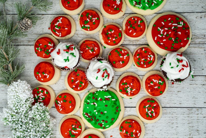 Variety of Christmas holiday treats with chocolate cupcakes and buttercream iced sugar cookies - top view flatlay on wood royalty free stock image Variety of Christmas holiday treats with chocolate cupcakes and buttercream iced sugar cookies - top view flatlay on wood royalty free stock image