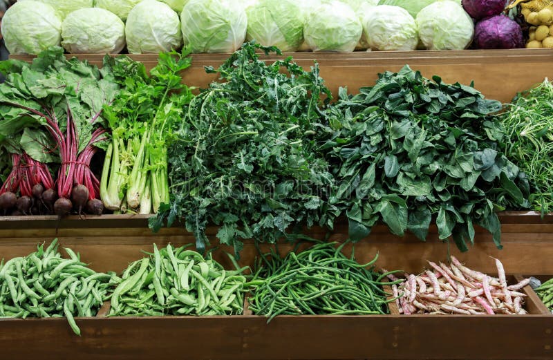 Variety of fresh vegetables cabbage, green leaves horta, spinach, celery, green beans, beets on the counter in the greek