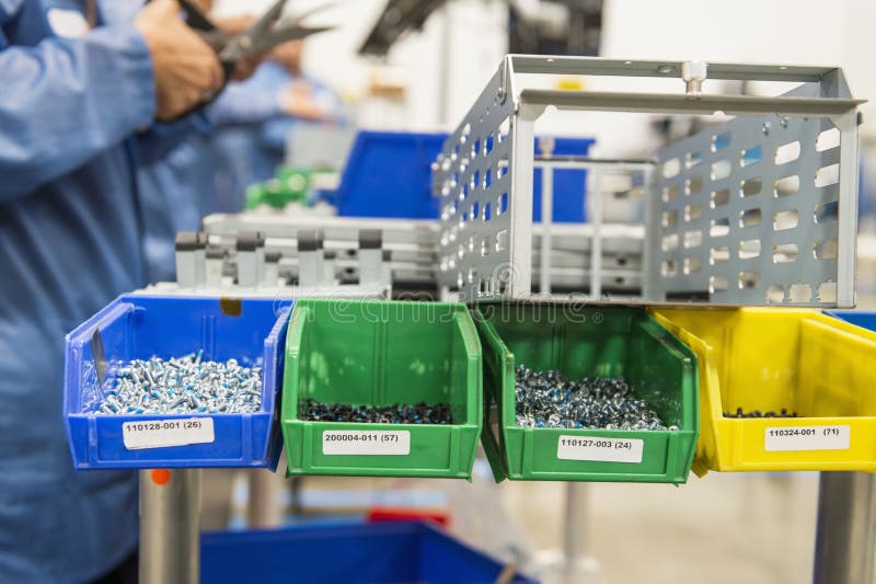 Variety of screws in tray with engineers working royalty free stock photo