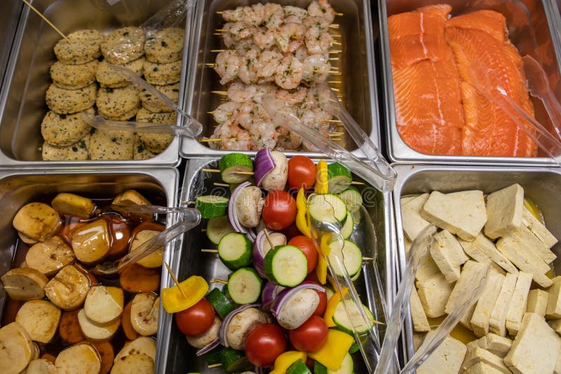 Variety of skewers and meats in the fridge. Variety of fresh skewers and meat products on the butcher display refrigerator in the Supermarket. salmon, shrimps royalty free stock images Variety of skewers and meats in the fridge. Variety of fresh skewers and meat products on the butcher display refrigerator in the Supermarket. salmon, shrimps royalty free stock images