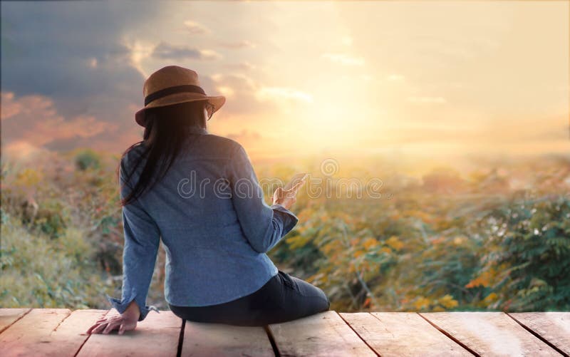 Variopinto astratto, donna che si rilassa con lo smartphone a disposizione sopra all'aperto in natura rurale di tramonto fotografie stock Variopinto astratto, donna che si rilassa con lo smartphone a disposizione sopra all'aperto in natura rurale di tramonto fotografie stock