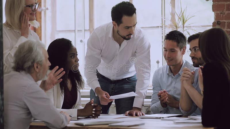 Varios equipos de negocios intercambian ideas sobre papeleo hablando riéndose de la reunión almacen de video