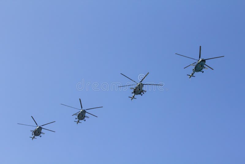 Varios helicópteros militares vuelan de lado a lado contra el cielo azul foto de archivo libre de regalías Varios helicópteros militares vuelan de lado a lado contra el cielo azul foto de archivo libre de regalías