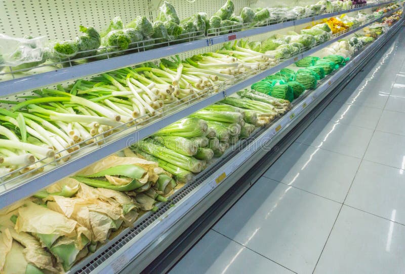 Various fresh organic green vegetables on display in supermarket. Background with lettuce, celery, alo vera, leek. Healthy vegetar